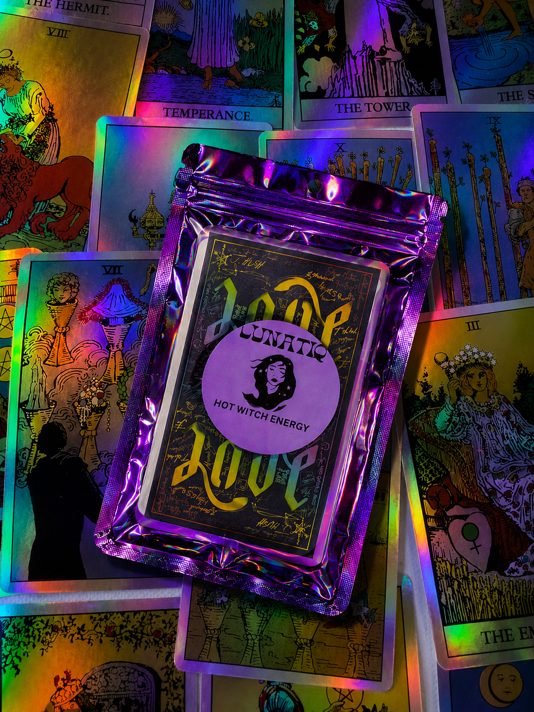 A Lunatiq Hot Witch Energy mystery package resting on an illuminated tarot spread